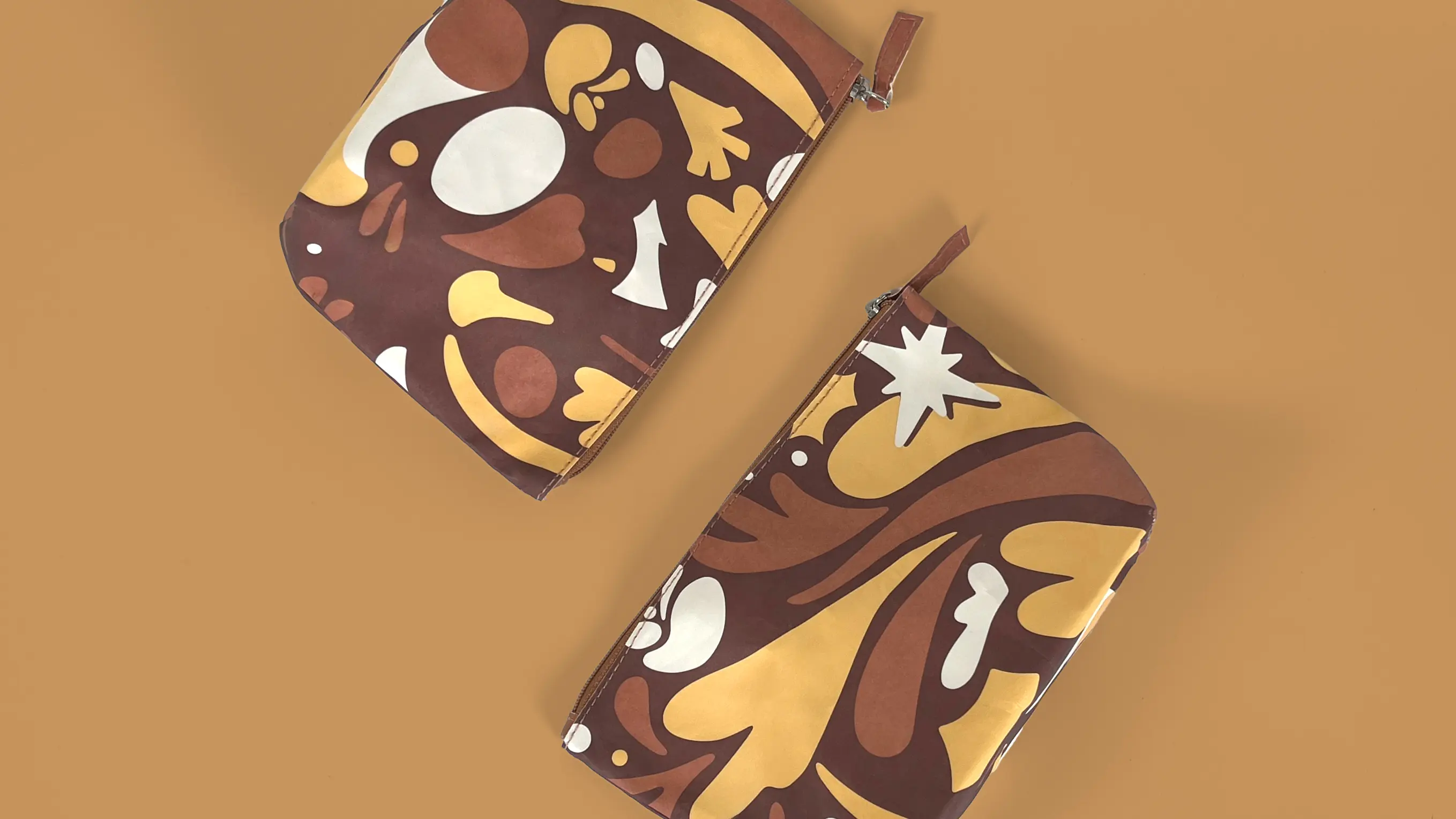 two bold cosmetic bags in warm brown, yellow & white tones, showcasing The Body Shop's vibrant accessories