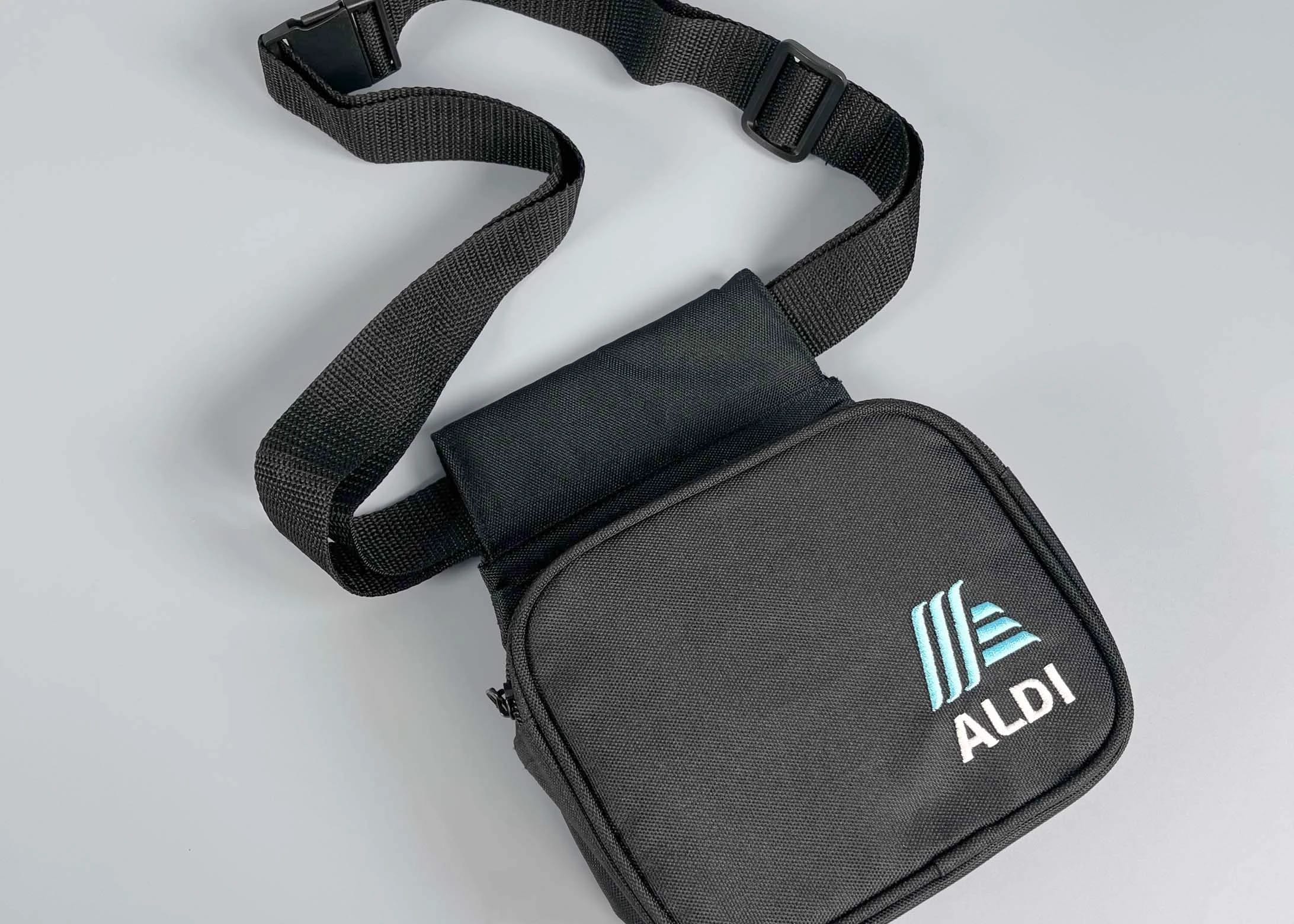 A sleek black crossbody bag with an adjustable strap by Dimensions