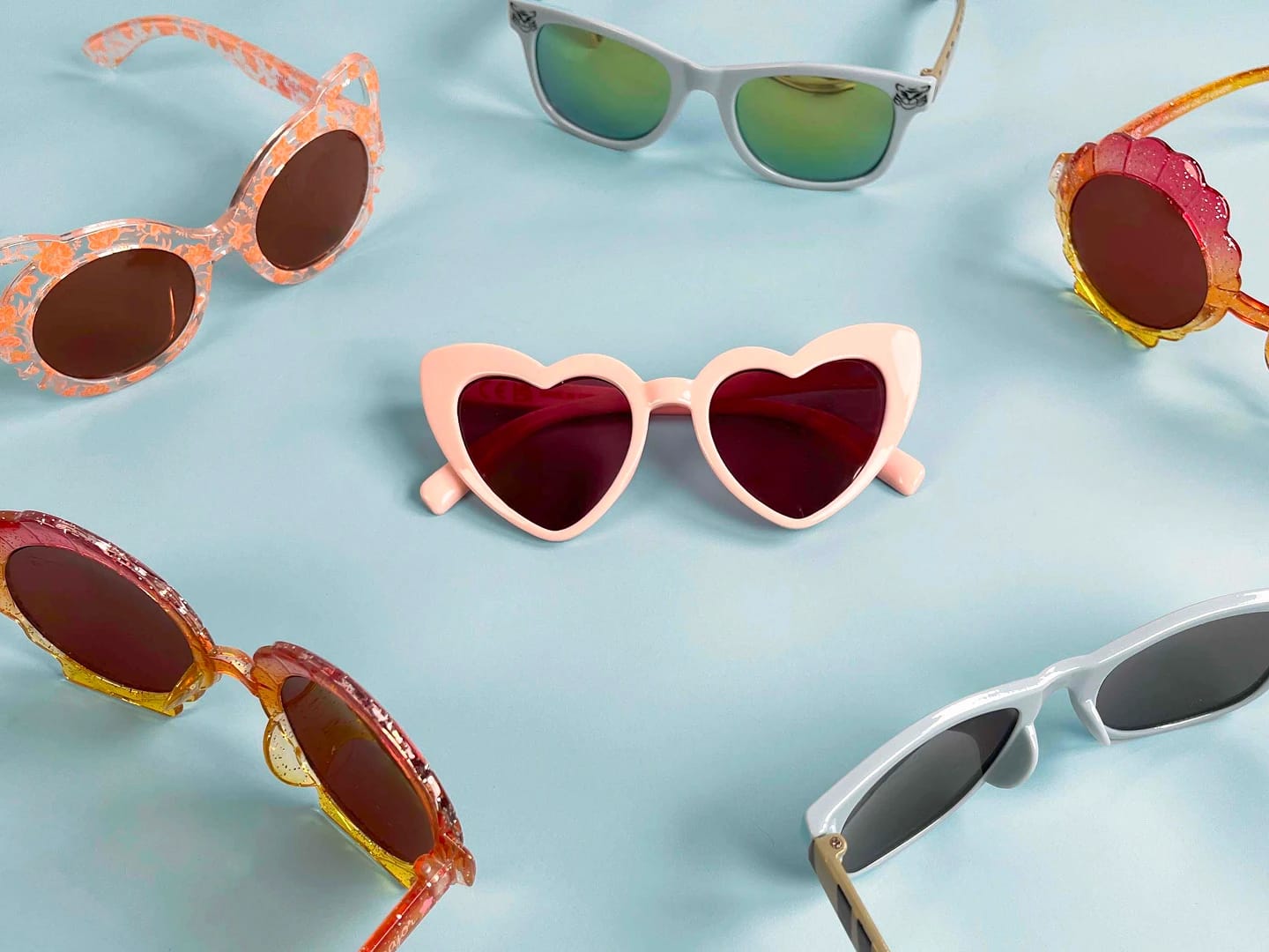 A collection of colorful sunglasses displayed in a circular layout, featuring Sergent Major